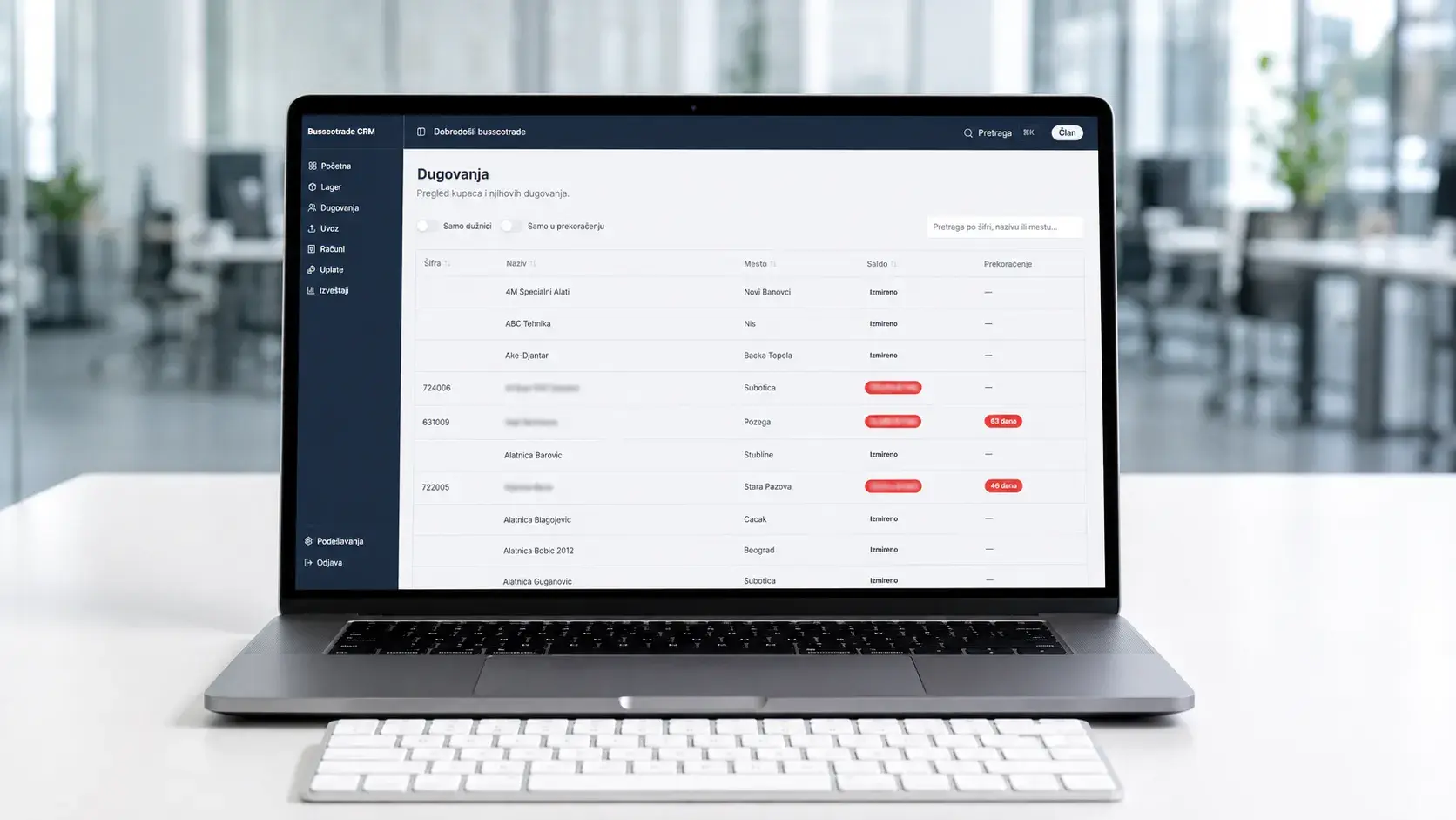Internal CRM receivables (Dugovanja) view on a laptop, listing customers, cities, and balance status